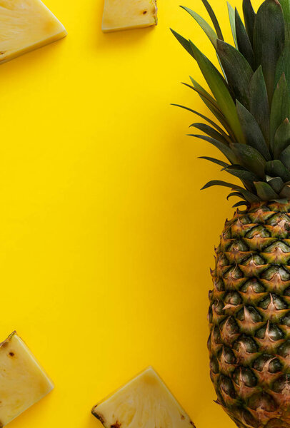 Тропическое гавайское происхождение с экзотическими фруктами. Ананас с ломтиками на желтом фоне.