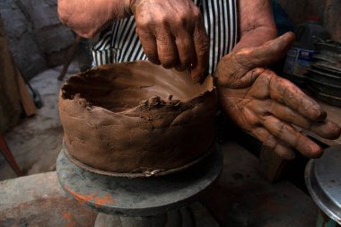 Kadın zanaatkarların elleri kil kaplar yapıyor. Bu kadınlar Venezuela 'daki balıkçılık camiasının kültürel mirasıdır..