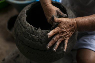 Kadın zanaatkarların elleri kil kaplar yapıyor. Bu kadınlar Venezuela 'daki balıkçılık camiasının kültürel mirasıdır..