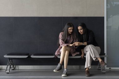 İki Latin Amerikalı kadın anne ve kız oturup ellerine ve tırnaklarına bakıyorlar. Aile kavramı, ilişkiler