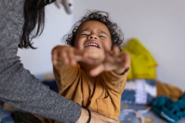 Latin Amerikalı çocuk (2), annesi elbiselerini değiştirdiği için üzgün. Çocukluk ve annelik bakımı kavramı
