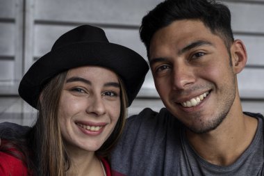 Kameranın önünde gülümseyen iki genç Latin Amerikalı kardeşin portresi. Kardeşlik ve aile kavramı