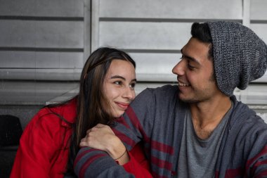 Mutlu gülümseyen iki genç Latin Amerikalı kardeşin portresi. Şefkat ve güvenlik göstergesi olarak kolunu tutuyor. Kardeşlik ve aile kavramı