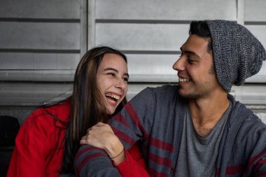 Mutlu gülümseyen iki genç Latin Amerikalı kardeşin portresi. Şefkat ve güvenlik göstergesi olarak kolunu tutuyor. Kardeşlik ve aile kavramı