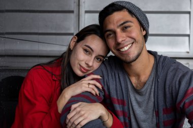 Mutlu gülümseyen iki genç Latin Amerikalı kardeşin portresi. Şefkat ve güvenlik göstergesi olarak kolunu tutuyor. Kardeşlik ve aile kavramı