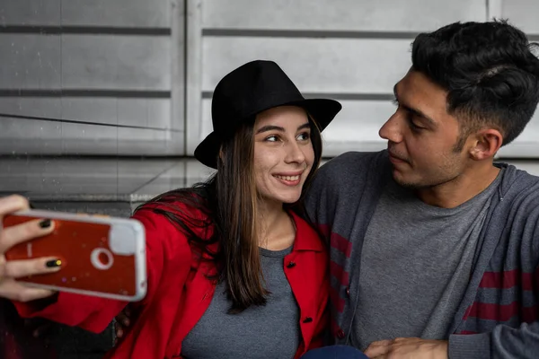 İki genç Latin Amerikalı kardeş birlikte vakit geçirip aile portresi çekiyorlar. Teknoloji konsepti.