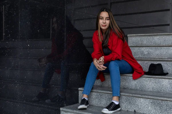 Merdivenlerde oturan genç Latin Amerikalı kadın portresi. Pozitif ve kendine güvenen pozlar. Portre konsepti