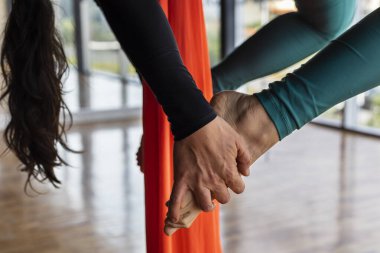 Sınıfta genç Latin Amerikalı kadın (33) hava jimnastik kumaşlarıyla dinlenme pozisyonu alıyor. Yoga ve sağlık konsepti.