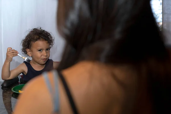 Latin Amerikalı çocuk koltuğunda tek başına oturmuş meyvelerini yiyor, o bağımsız bir çocuk. Annelik ve mutluluk kavramı