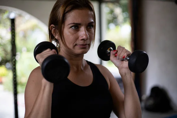 Concentrated Latin American Woman Lifts Dumbbells Workout Gym Healthy Lifestyle — Stockfoto