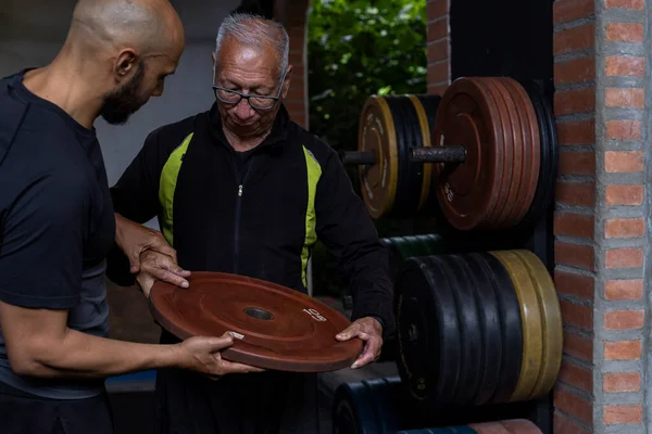 Older Latin American Man His Trainer Hold Weight Disc Hands — Stockfoto