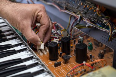 Latin Amerikalı elektronik teknisyen servis merkezinde bir piyano tamir ediyor. Konsept onarımı, müzik, elektronik