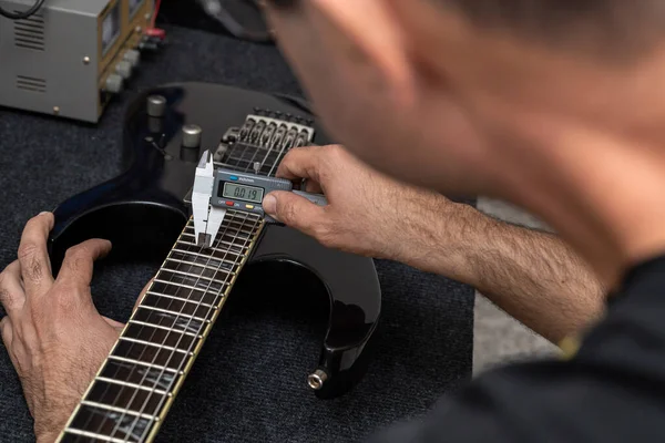 拉丁美洲的吉他手用数字游侠来校准电吉他的弦 无法辨认 吉他概念 — 图库照片