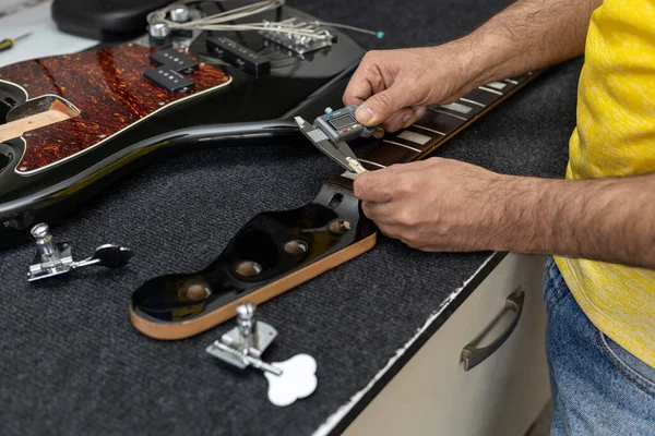 Latin Amerika luthier dijital bir vernier ile elektrikli bas capo 'nun kalınlığını ölçer. Tanınmaz halde. Bas kavramı, kalibrasyon, enstrüman.