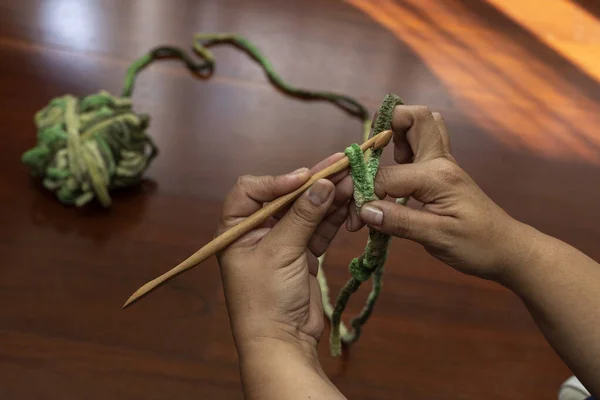 Bambu tığ işi iğneyle örgü ören bir kadının ellerinin yakın çekimi. Boş zaman ve boş zaman kavramı