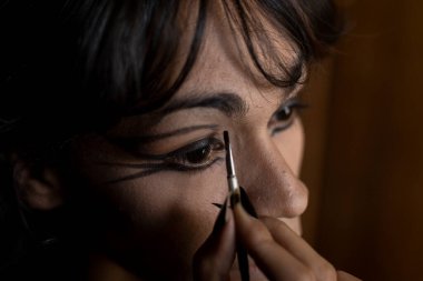 Genç travesti (26) odasında makyaj yapıyor. Transseksüel Konsepti