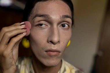 22 yaşında transseksüel genç bir erkek odasında makyaj yapıyor. Transseksüel kavramı