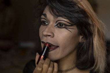 Genç travesti (26) odasında makyaj yapıyor. Transseksüel Konsepti