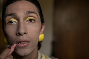 Genç travesti (22) odasında makyaj yapıyor. Transseksüel Konsepti