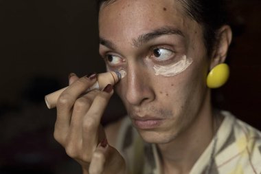 22 yaşında transseksüel genç bir erkek odasında makyaj yapıyor. Transseksüel kavramı