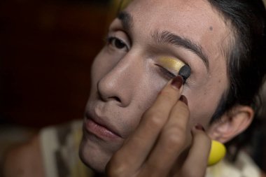 22 yaşında transseksüel genç bir erkek odasında makyaj yapıyor. Transseksüel kavramı