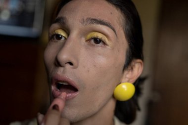 22 yaşında transseksüel genç bir erkek odasında makyaj yapıyor. Transseksüel kavramı