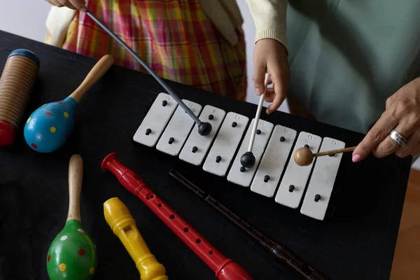 Latin American music teacher giving rhythmic music lessons with a xylophone