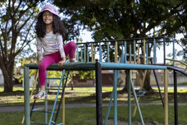 Latin American girl with positive attitude playing in the playground