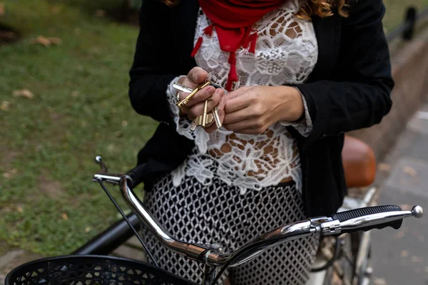 若いですラテンアメリカのビジネス女性とともに彼女のヴィンテージ自転車と家の鍵で彼女の手 — ストック写真