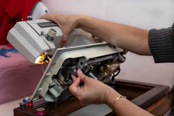 Latin Amerikalı terzi dikiş makinesine iplik makarası yerleştirdi