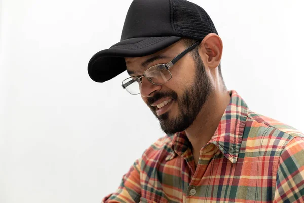 Portrait of Latin American man with cap and glasses.