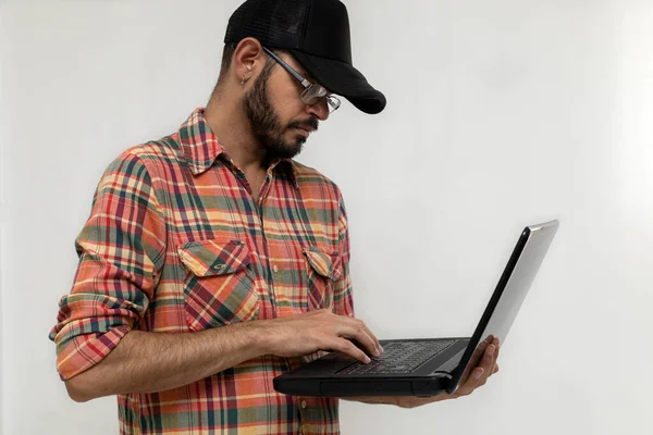 Latin American man with his laptop computer is a programmer and specializes in web development.