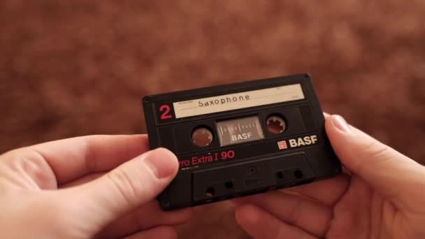 An old audio cassette in the hands of a close-up. Ferro Extra I 90. BASF cassette — Stock Video