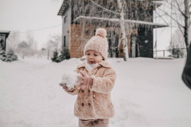 Küçük bir kız kartopu yapıyor. Yüksek kalite fotoğraf