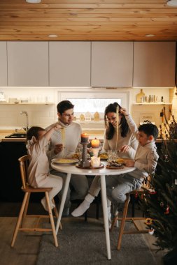 Dört kişilik bir aile bir masada oturup yemek yiyor.