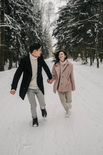 Jovem Casal Feliz Corre Longo Estrada Uma Floresta Nevada Foto — Fotografia de Stock