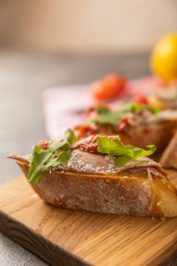 Ahşap bir tahtanın üzerinde somon avokadosu ve roka ile nefis bir bruschetta..