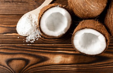 Tahta kaşıkta hindistan cevizi taneleri, tahta arka planda hindistan cevizi. Yakın plan. Boşluğu kopyala.