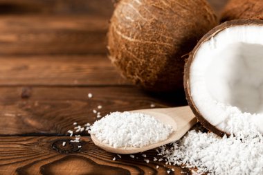 Tahta kaşıkta hindistan cevizi taneleri, tahta arka planda hindistan cevizi. Yakın plan. Boşluğu kopyala.