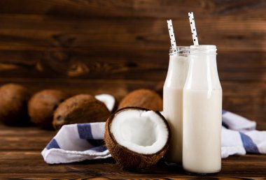 Hindistan cevizli yoğurt ve ahşap arka planda hindistan cevizi. Yakın plan..