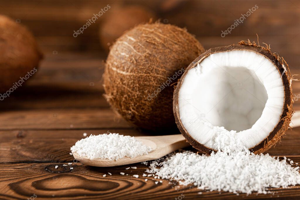 coconut flakes on a wooden spoon, coconuts on a wooden background. Close-up. copy space.