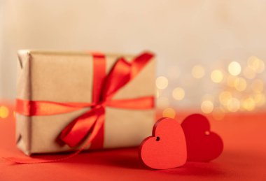 Hediye kutusu, kırmızı kalp ve kırmızı arka planda bir fincan çay. Sevgililer günü hediyesi. Tatiller ve aşk konsepti.