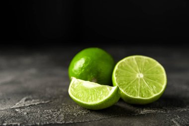 Koyu arkaplanda sulu olgun turunçgil meyveleri. İçecekleri ve kokteylleri hazırlamak için gerekli malzemeler. Mojito. Seçici odak, üst görünüm ve boşluk kopyala