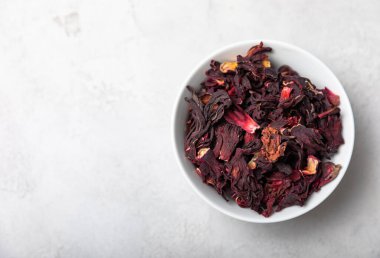 Hibiscus çayı. Beyaz bir seramik kasede gri bir arka planda Hibiscus çayı. Soğuk algınlığı ve grip için vitamin çayı. Boşluğu kopyala..