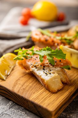 Lezzetli bruschetta ya da somonlu kanepe. Tuzlu somon, roka ve ahşap tahtada krem peynirli sandviç..