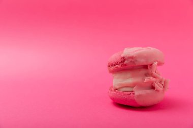 Yumuşak pembe kağıt arka planda lezzetli pembe makaron. Bademli kurabiyeler. Mutfak ve yemek konsepti. Yan görüş. Uzayı kopyala Metin için yer.