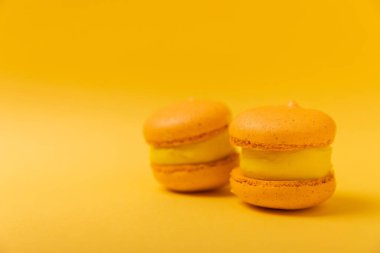 Yumuşak sarı-turuncu kağıt arka planda lezzetli çilekli kurabiyeler. Fransız kurabiyeli kurabiye. Mutfak ve yemek pişirme konsepti. Boşluğu kopyala. 