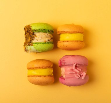 Yumuşak sarı-turuncu kağıt arka planda lezzetli çilekli kurabiyeler. Fransız kurabiyeli kurabiye. Mutfak ve yemek pişirme konsepti. Uzayı kopyala en üstteki görünüm.