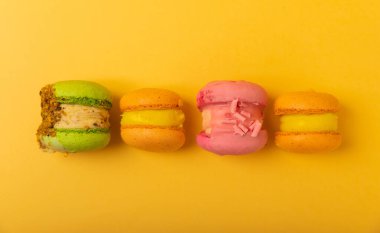 Yumuşak sarı-turuncu kağıt arka planda lezzetli çilekli kurabiyeler. Fransız kurabiyeli kurabiye. Mutfak ve yemek pişirme konsepti. Boşluğu kopyala. 