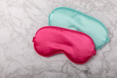 Mermer bir arka planda iki saten uyku maskesi. Asgari dinlenme konsepti, uyku kalitesi, iyi geceler, uykusuzluk, rahatlama, tatlı rüyalar. Uzayı kopyala Düz yat, üstten bak, maket yap.
